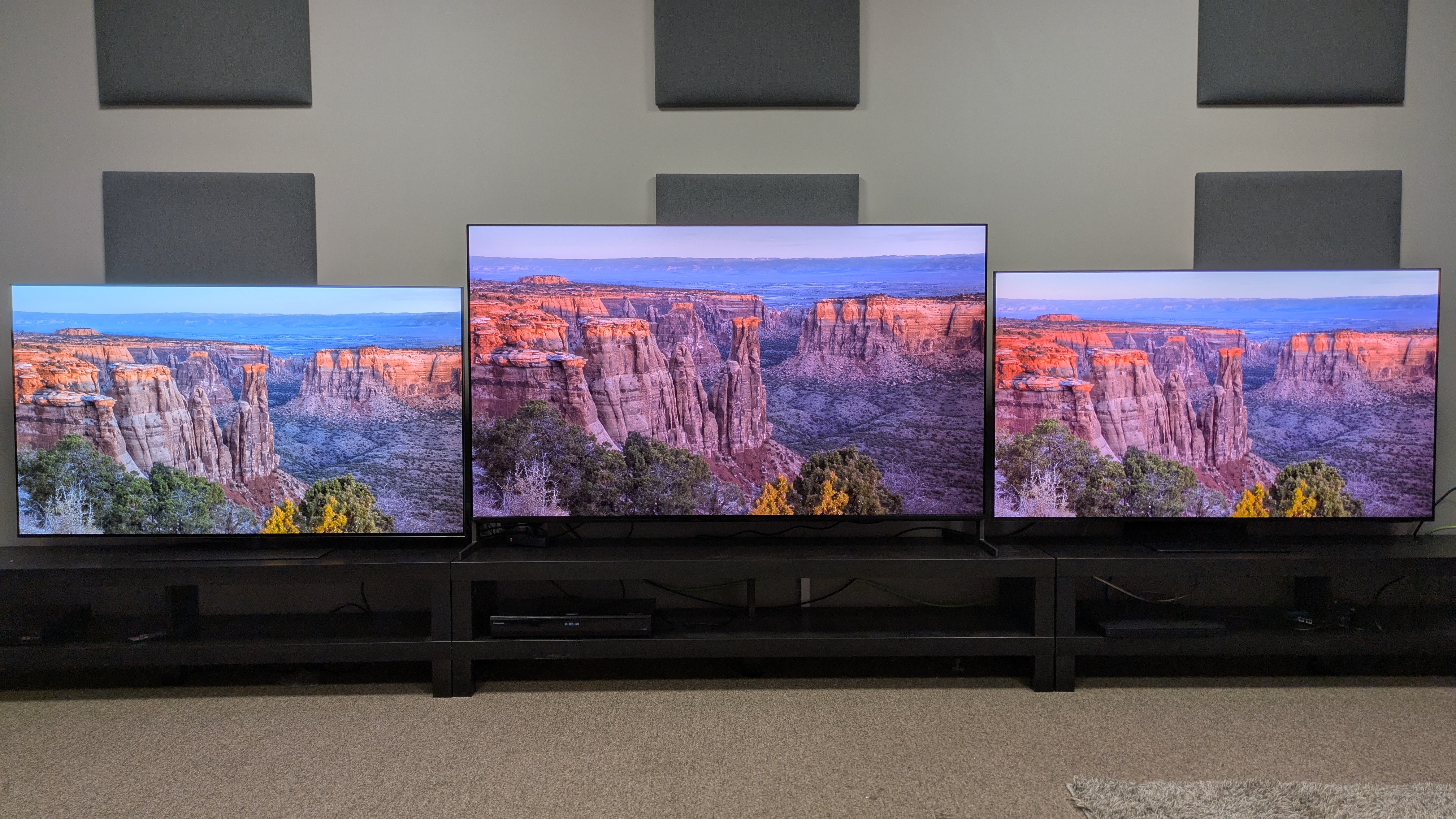 LG G5 (left), Sony Bravia 8 II (center) and Samsung S95F (right) showing cliff in desert canyon at sunrise on screen