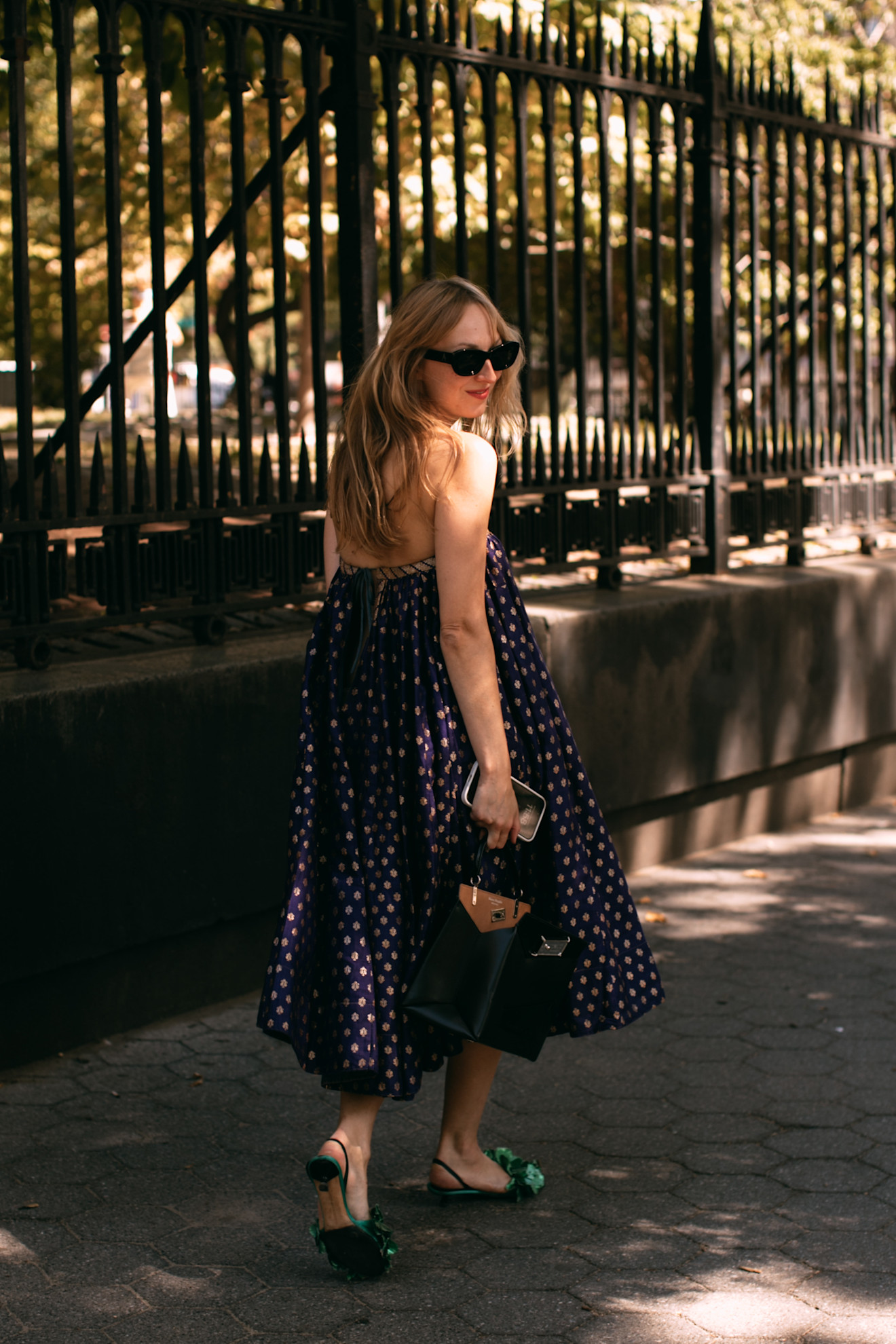 A New Yorker woman wears a polka dot dress and green flats