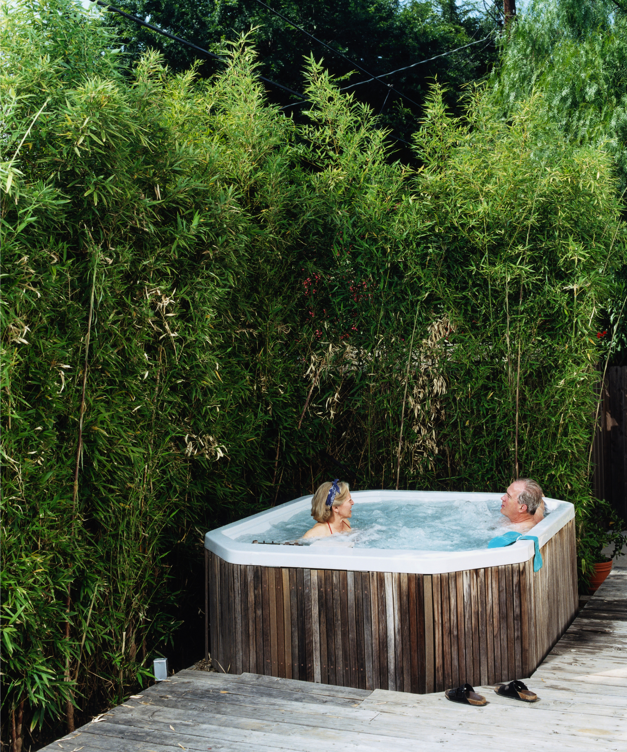 older couple in a hot tub surrounded by bamboo