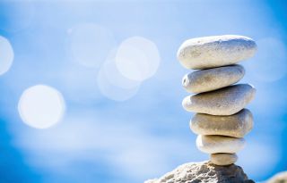 Tall stack of smooth stones in front of blue sky