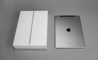 View of an iPad Pro and its box pictured against a grey background