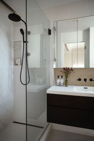 small bathroom with floating vanity, glass shower screen, yellow backsplash and hand soap