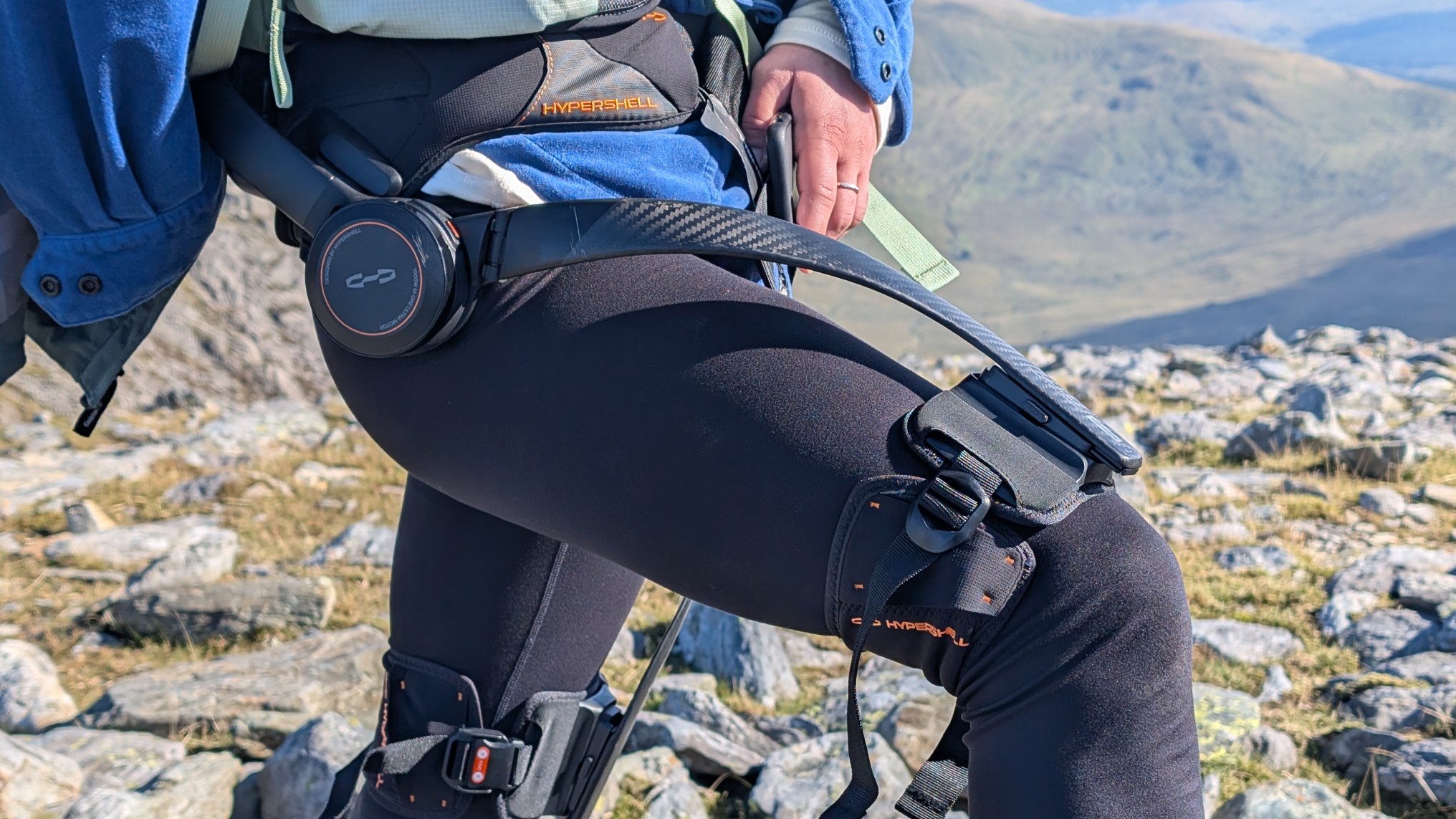 Julia Clarke hiking up Ben Nevis with a Hypershell X ultra on a sunny day