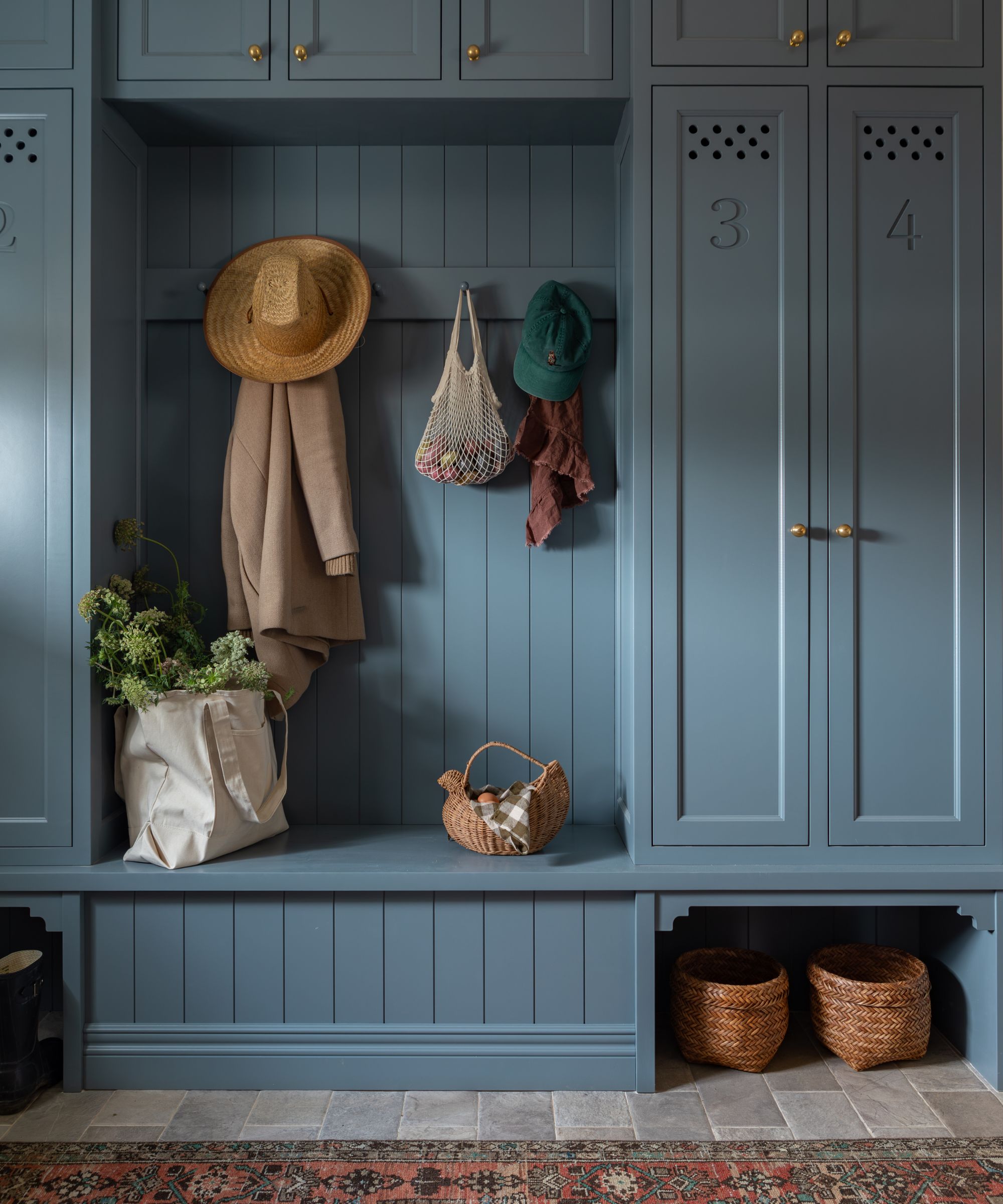 blue color drenched boot room with custom storage cupboards and a tongue and groove panelled bench