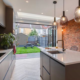 black bifold doors in kitchen extension leading to small garden