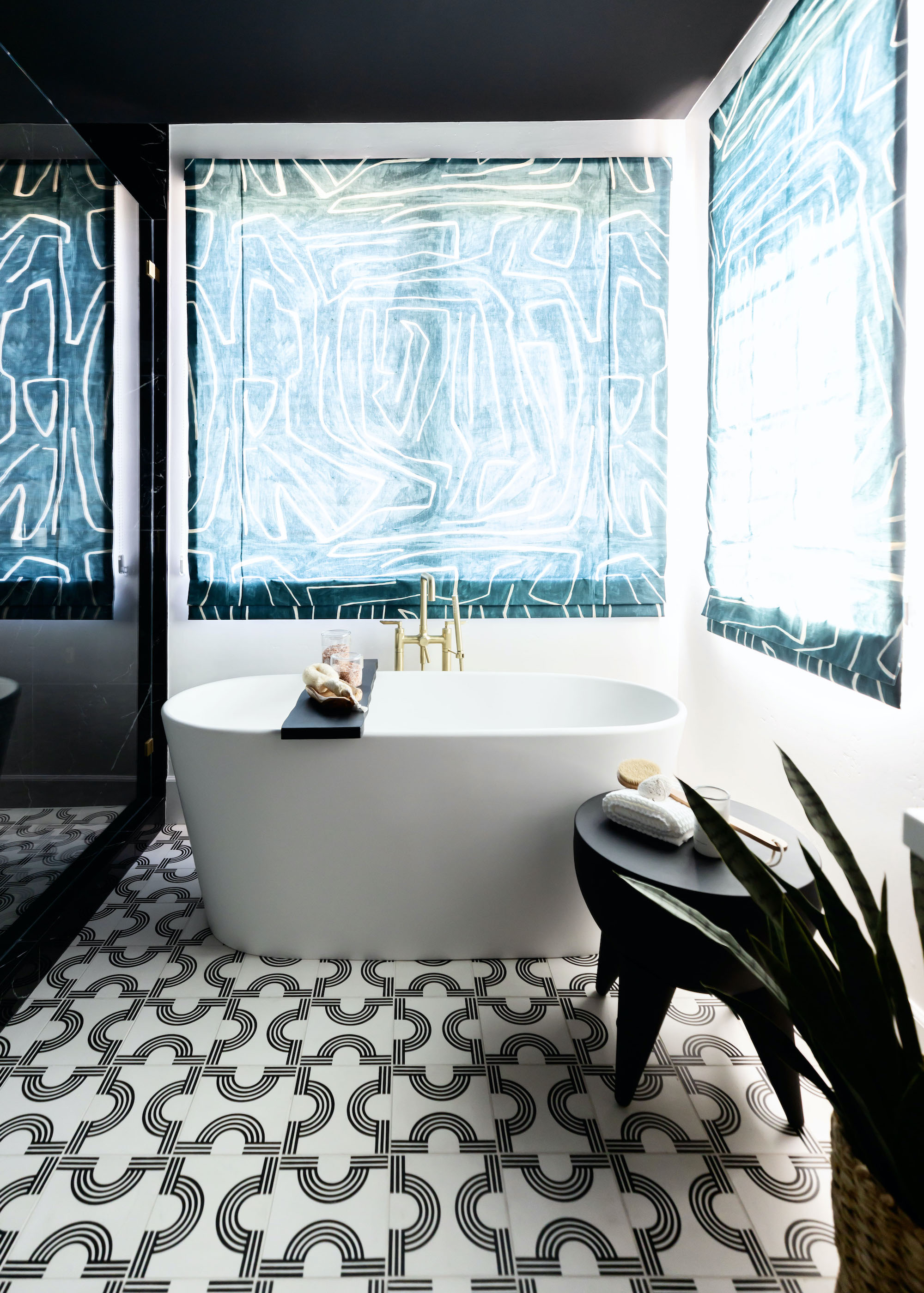 bathroom with freestanding bath and puzzle patterned floor tiles and abstract blinds