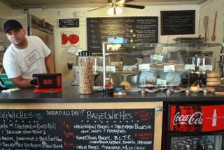 a cook leans over a bagel shop counter in Diners drive ins and dives