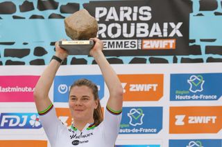 Team SD Worx - Protime's Belgian rider Lotte Kopecky celebrates on the podium with the cobblestone trophy after winning the fourth edition of the women's Paris-Roubaix one-day classic cycling race, 148,5km between Denain and Roubaix, on April 6, 2024. (Photo by Thomas SAMSON / AFP)