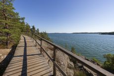 Elevated wooden seaside walkway on a cliff by the Baltic sea in Mariehamn, Åland Islands, Finland, on a sunny day in the summer. 