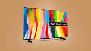 En LG C2 4K TV på 42 tum visas upp mot en ljusbrun bakgrund.