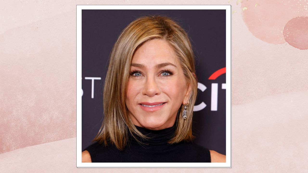 Image of Jennifer Aniston smiling with a blonde side part bob and a black high-neck dress, on a pink background