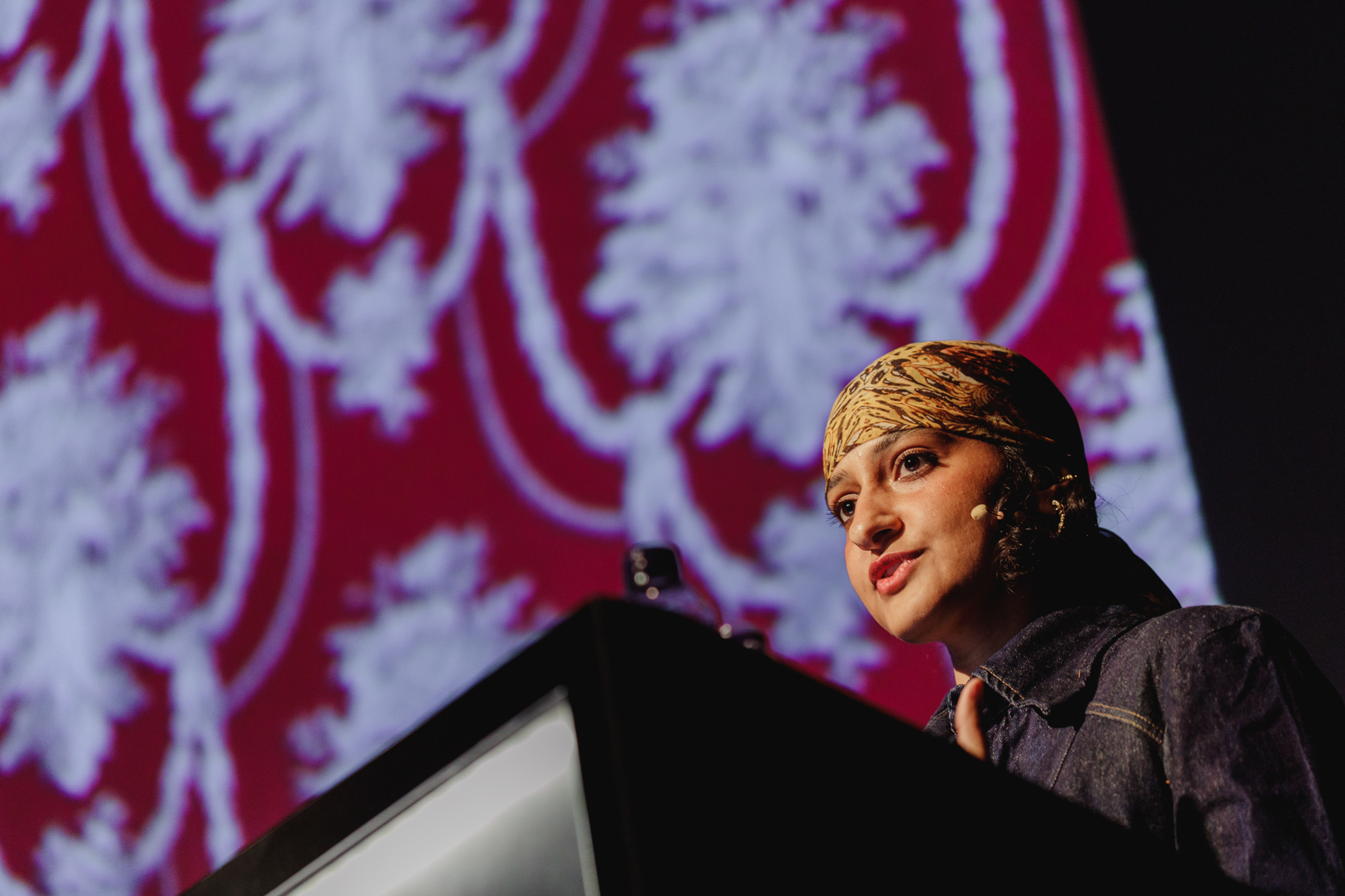 A low-angle shot shows a person wearing a patterned head covering