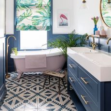 bathroom with blue and white wall and bathtub and washbasin and tiles floor