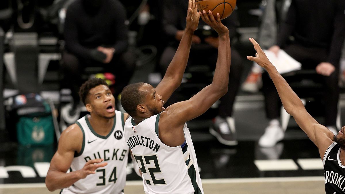 Khris Middleton #22 of the Milwaukee Bucks shoots the game winning basket as teammate Giannis Antetokounmpo looks on in the final minutes of overtime during game seven of the Eastern Conference second round at Barclays Center on June 19, 2021 in the Brooklyn borough of New York City.