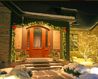 Christmas porch decor with garland red ribbons and lights