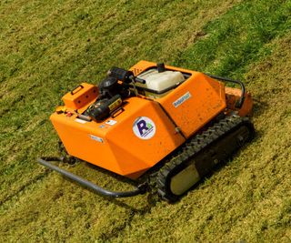 A remote-controlled lawn mower on a slope