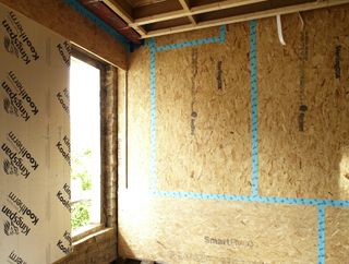 An internal wall being fitted with solid board insulation
