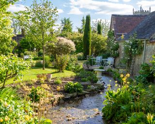 stream in a english garden with metal bistro set