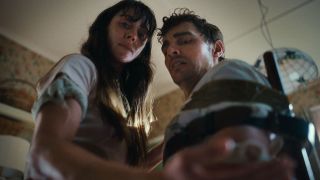 alison brie and dave franco as a frightened couple looking down at something in a still from the movie together