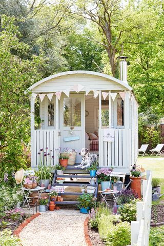 shepherd's hut in cottage garden with flowers and garden path