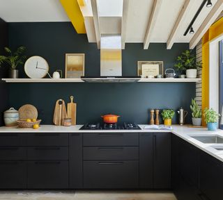 black modern kitchen cabinets with dark kitchen walls and an open shelf with decorative pieces