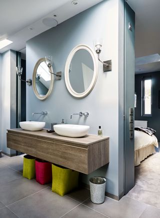 modern en suite with two sinks, two mirrors and wall mounted storage