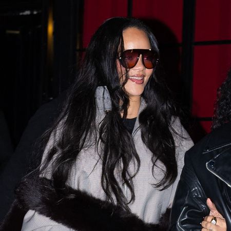 Rihanna wearing black sunglasses, plaid funnel neck jacket, slit leggings, and red lace up pumps