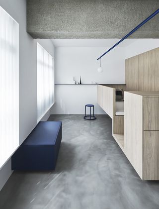Interior of Alex's apartment in Singapore with wood features, white walls and grey floor