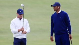 Rory and Tiger chat whilst Rory holds a wedge