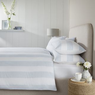 Blue and white stripy bedding in white bedroom