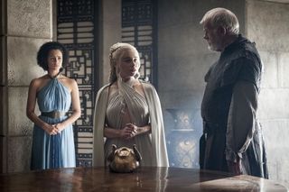 Scene from 'Game of Thrones': Season 5, Episode 1; women with hands folded talking to tall man by wooden table