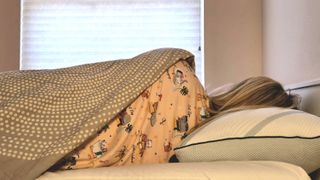 Sleep tester Alison resting on her side on the Tempur-Pedic Tempur-Adapt ProAdjust Pillow with her back toward the camera