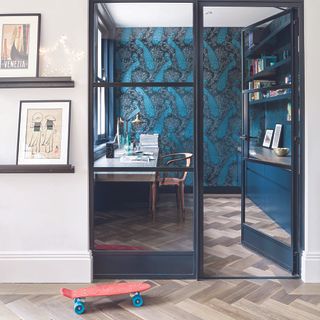 Home office with crittall doors and blue wallpaper.