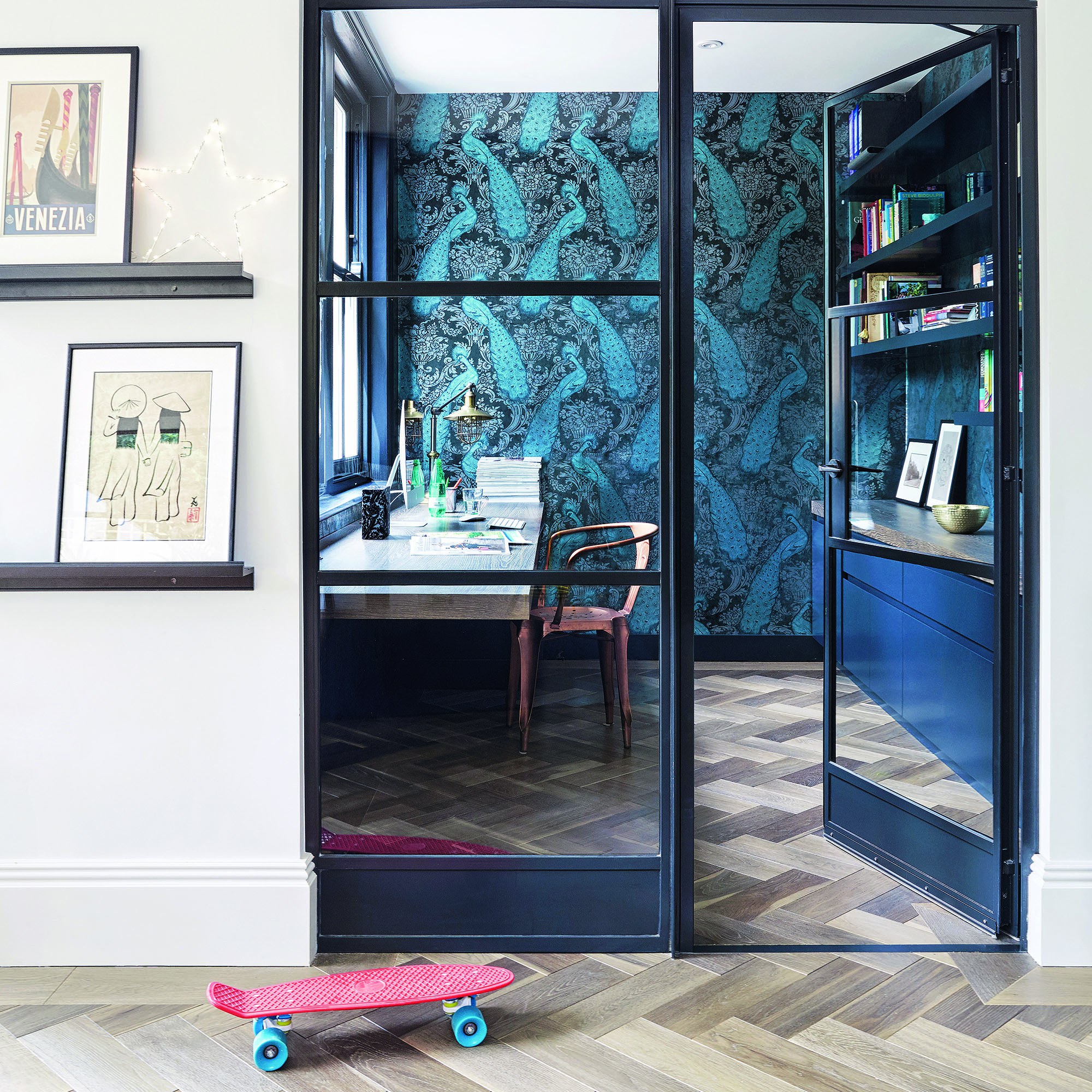Home office with crittall doors and blue wallpaper.