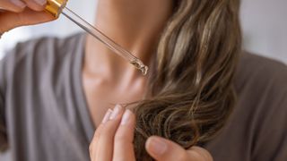 woman applying serum to hair