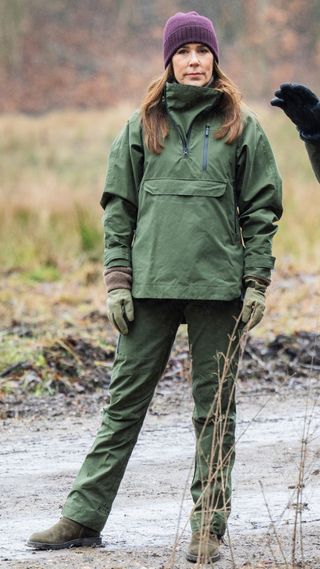 Queen Mary wearing waterproof khaki co-ord, green gloves and plum beanie