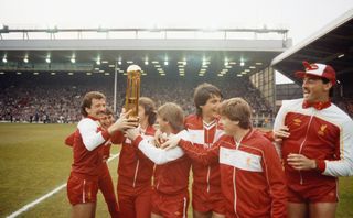 Liverpool players celebrate with the First Division trophy in May 1984 after winning the league for a third year in a row.