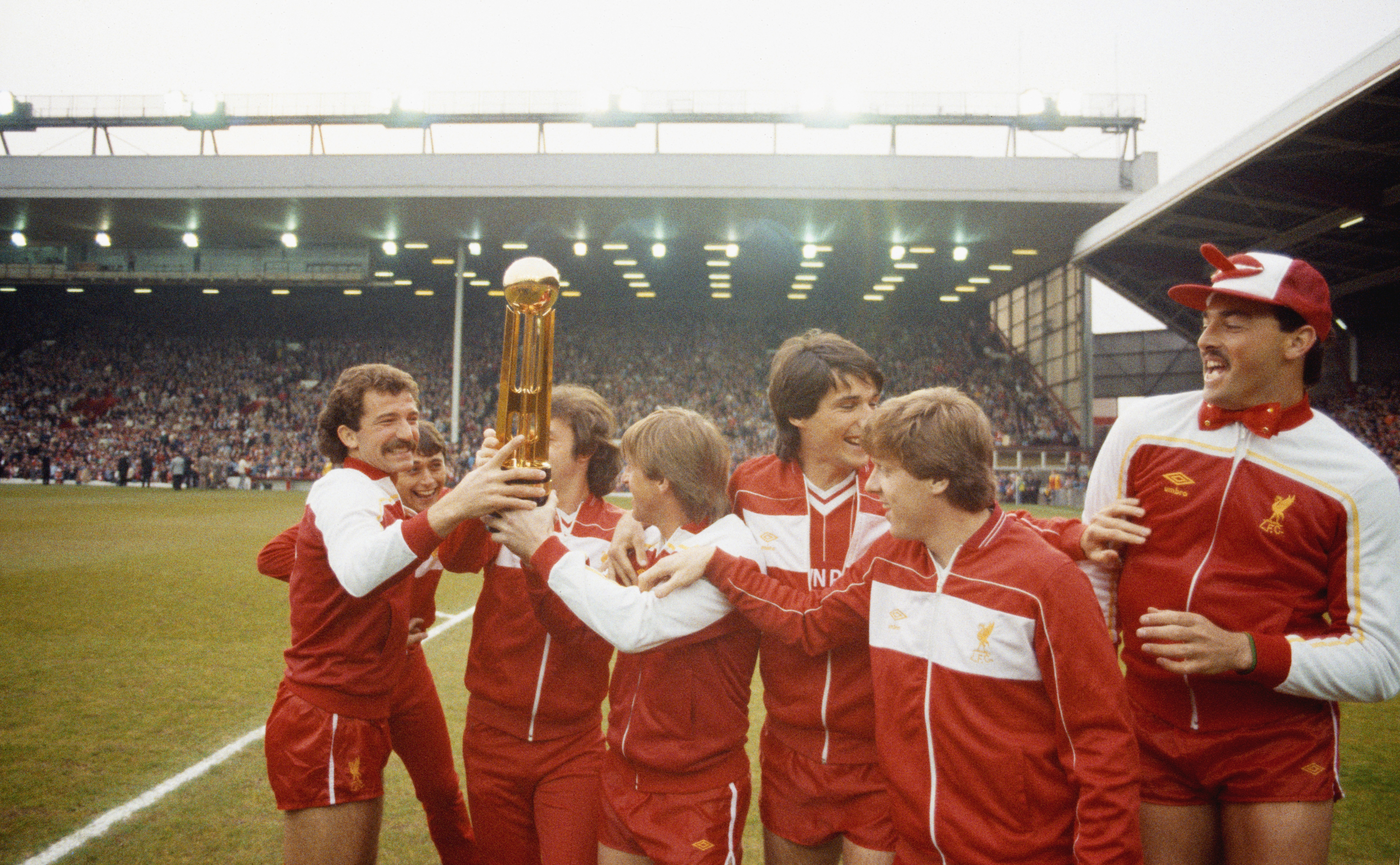 Liverpool players celebrate with the First Division trophy in May 1984 after winning the league for a third year in a row.