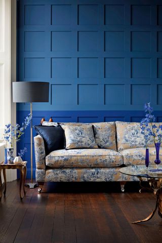 Floral sofa in blue panelled living room