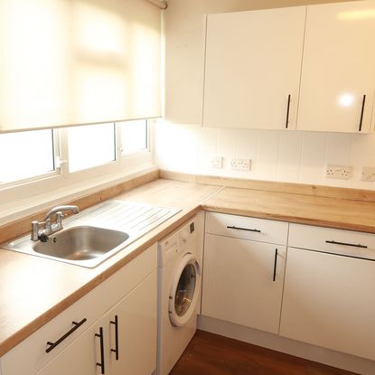 kitchen with wooden counter and white cabinets