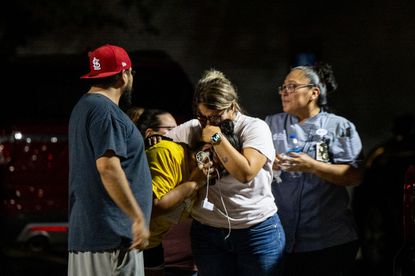 Texas school shooting: A group embrace outside Willie de Leon Civic Center in Uvalde, Texas, US, on Tuesday, May 24, 2022. President Joe Biden mourned the killing of at least 19 children and two teachers in a mass shooting at a Texas elementary school on Tuesday, decrying their deaths as senseless and demanding action to try to curb the violence. Photographer: Eric Thayer/Bloomberg via Getty Images