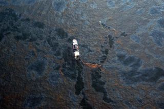 A boat works to collect oil that has leaked from the Deepwater Horizon wellhead in the Gulf of Mexico on April 28, 2010 near New Orleans, Louisiana. An estimated leak of 1,000 barrels of oil a day are still leaking into the gulf.