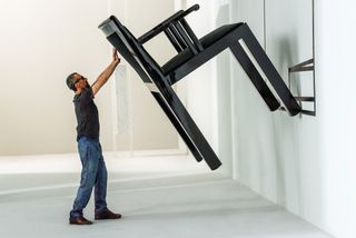 Man holds up giant chair