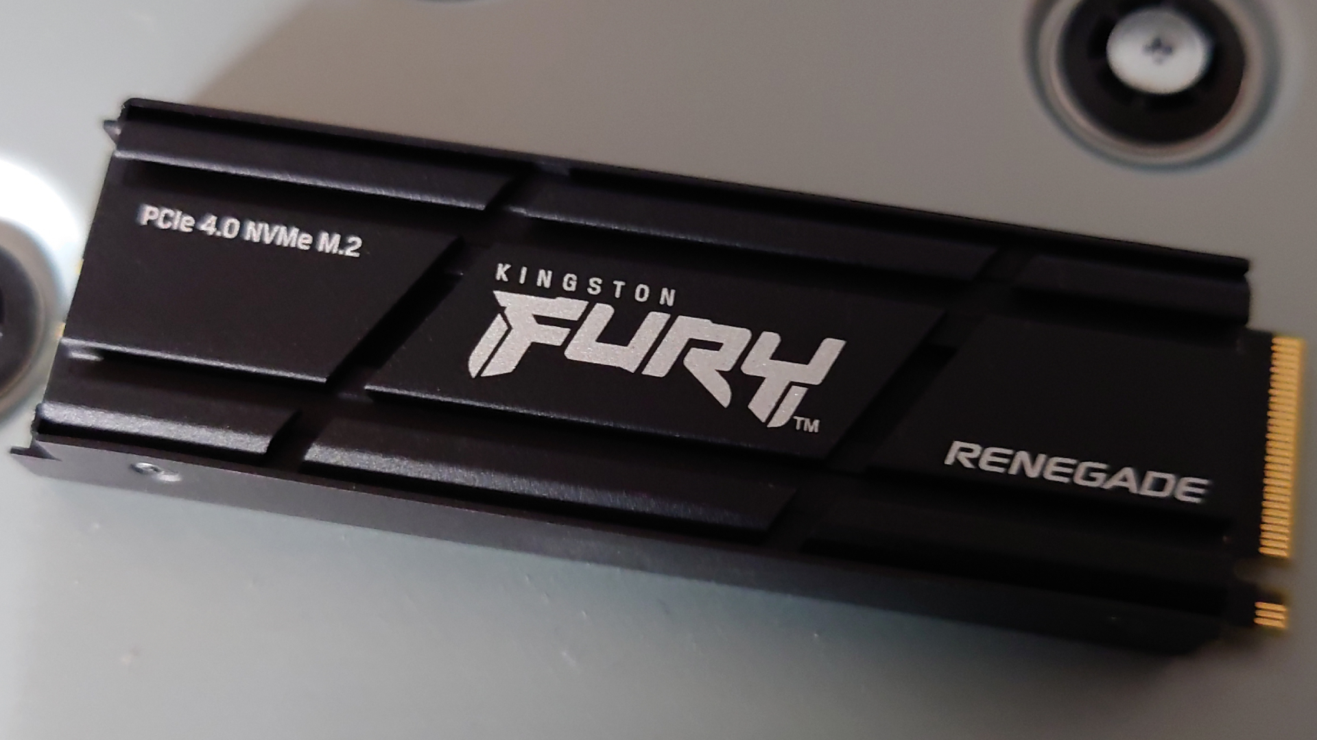 Musta Kingston Fury Renegade -SSD harmaalla taustalla