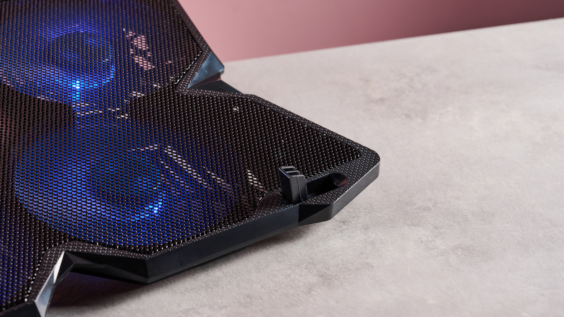 A closeup of the bottom right fan of the Klim Wind, spinning and lit up in blue.
