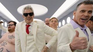 Johnny Knoxville and Steve-O in white suits with a shirtless Preston Lacy all looking at the camera