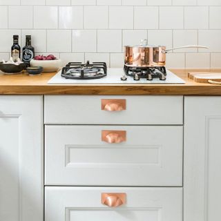 kitchen with copper cookery and white cabinet
