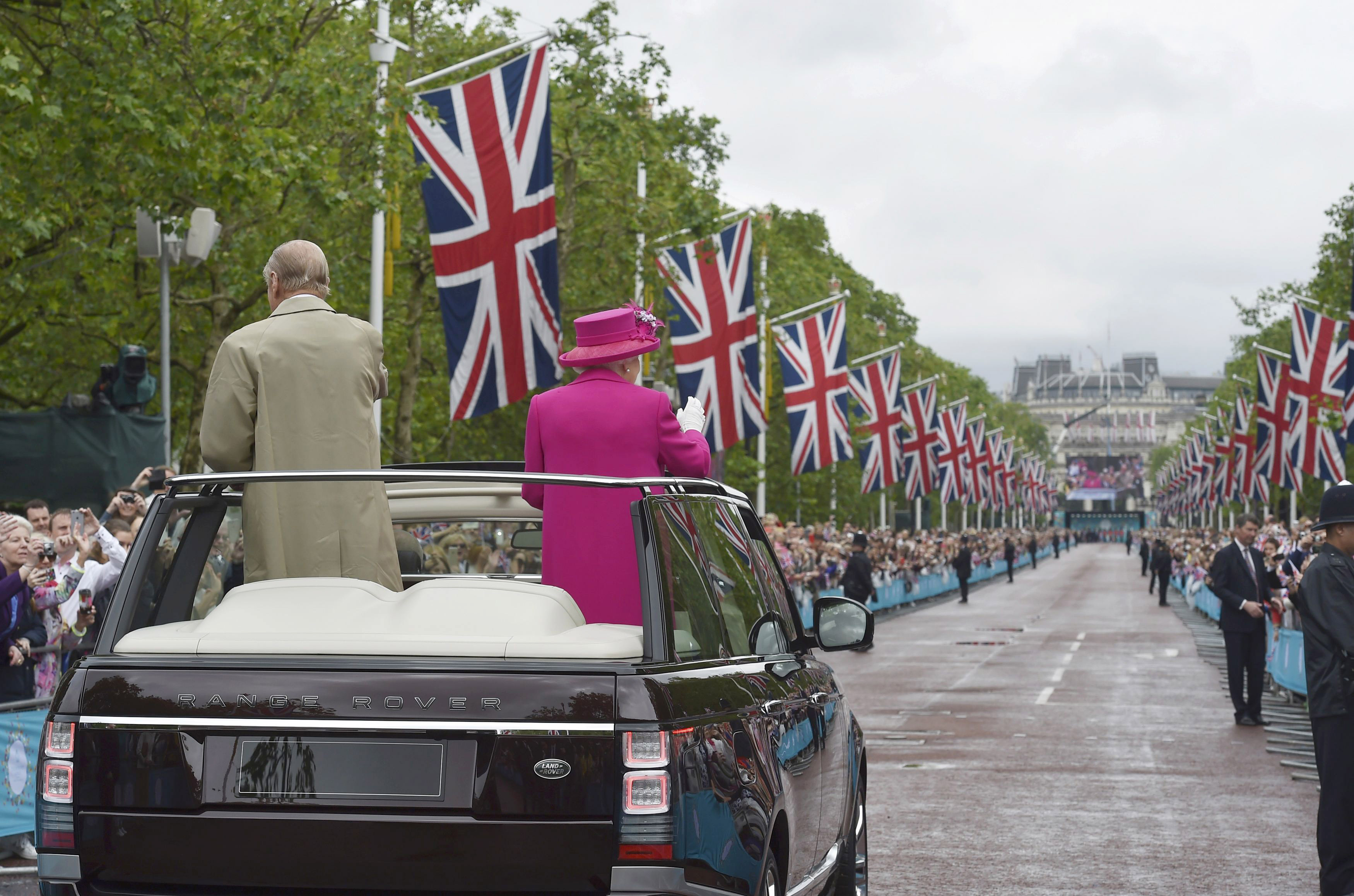 QUeen Elizabeth and Prince Philip riding in an open top car