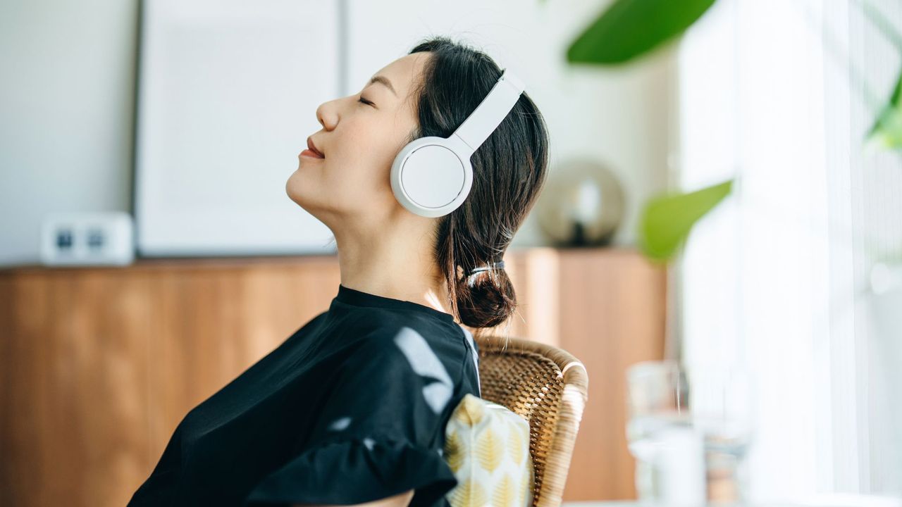 How to switch off: A woman sat relaxing with her headphones on