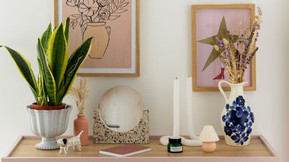 Colourful bedroom with blue sideboard for storage and a gallery wall of botanical art prints